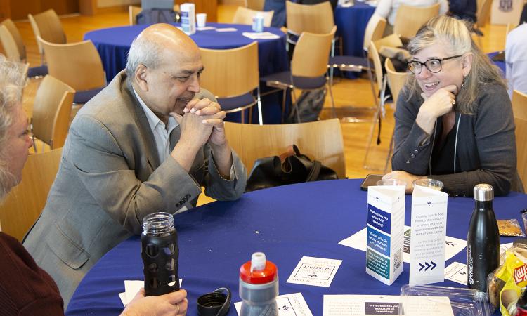 Ashok Goel, left, sits with faculty and staff members discussing educational research topics.