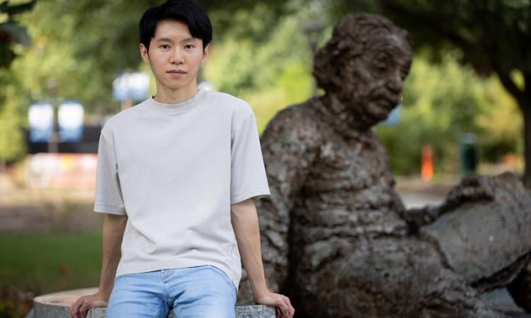 Ray Hung sitting in front of Georgia Tech's Einstein sculpture.