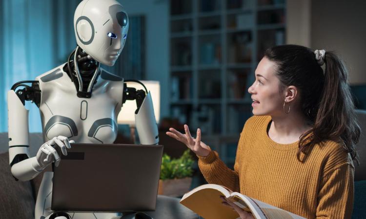 A humanoid with a computer listens to a woman talking.