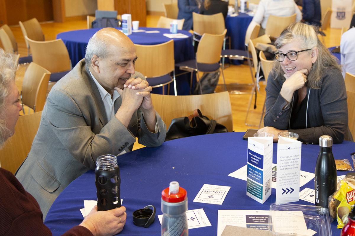 Ashok Goel, left, sits with faculty and staff members discussing educational research topics.